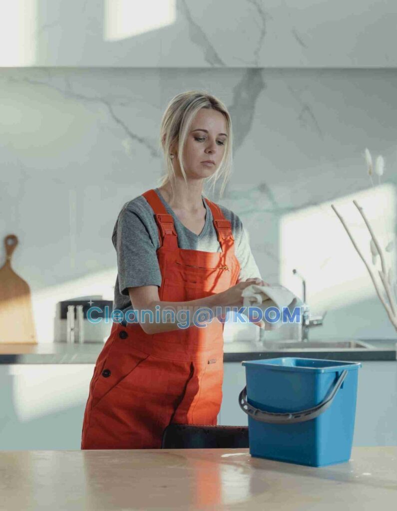UKDOM cleaner wiping a kitchen worktop in a Central London flat