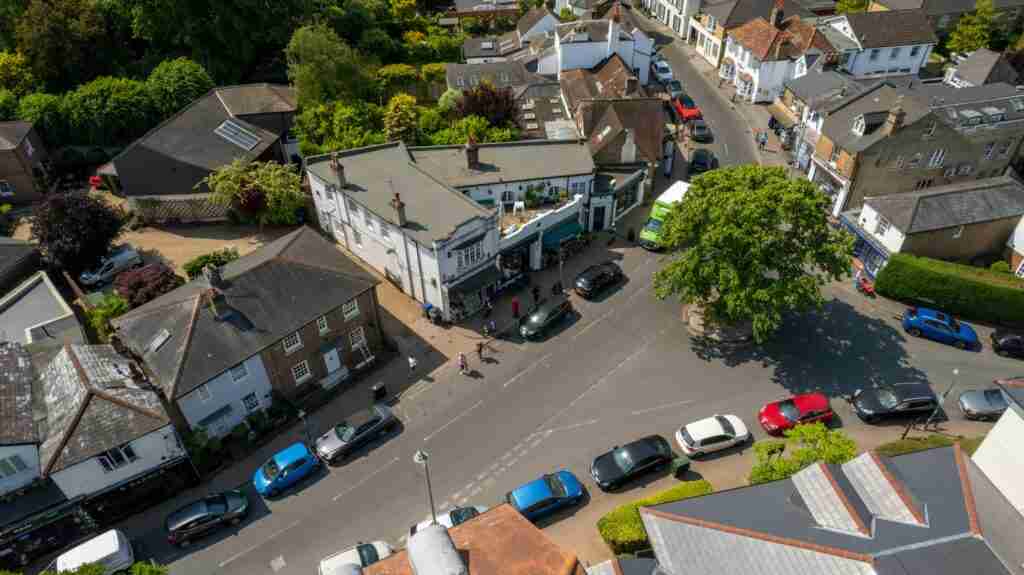 Aerial shot of a bustling street corner in Thames Ditton, England during summer.